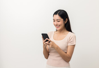 Excited Beautiful young asian woman using smartphone mobile standing on isolated white background. Playing game on smartphone winning victory moment. Very happy enjoy and fun relax time