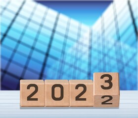 Canvas Print - Flipping wooden cubes 2022 to 2023 with blue background. Happy new year 2023.