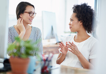 Poster - passionate about their work. shot of two young female designers discussing work in the office.