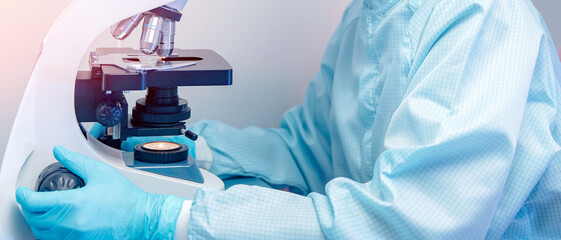 Wall Mural - banner microscope with metal lens at laboratory with hand of pharmacology worker. concept industry l