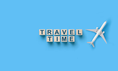Wall Mural - traveling concept , wooden cubes with travel time words and airplane model