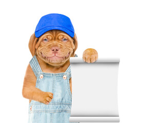 Poster - Smiling puppy wearing  blue cap and overalls shows empty list. Isolated on white background