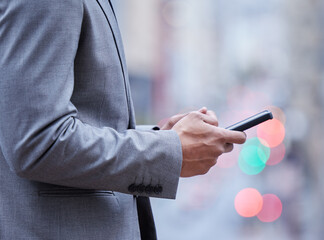 Poster - Staying on top of the latest business news. Cropped shot of an unrecognisable businessman standing alone and using his cellphone.