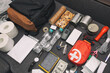 © SkyLine - Emergency backpack equipment organized on the table. Documents, water,food, first aid kit and another items needed to survive.