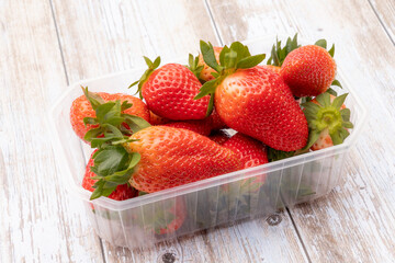 Wall Mural - whole red strawberries isolated in a punnet on a white background