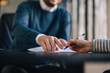 © bnenin - Close up a female signing contract, male showing where to put a