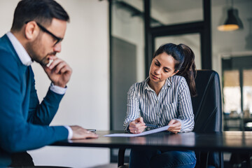 Focused people, a woman showing something to her male boss.