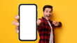 Excited guy pointing at white empty smart phone screen