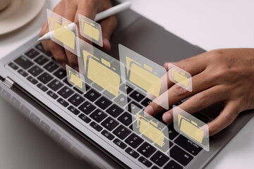 Leinwandbilder - Paperless workplace idea based on e-documents. On a virtual screen, a businessman works on a laptop computer keyboard with electronic document icons.