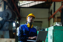 Male Worker Or Engineer Inspecting Industrial Machinery. The Concept Of A Heavy Industrial Plant.