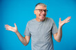 Middle age man over blue background clueless and confused expression with arms raised