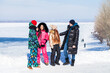 © Andrey_Arkusha - Young family of four walking outdoors in winter