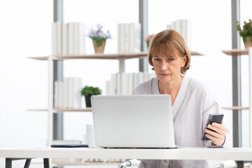 Wall Mural - senior businesswoman or freelancer looking smartphone for checking something for work