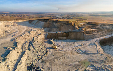 Wall Mural - Aerial view of open pit mine of sandstone materials for construction industry with excavators and dump trucks. Heavy equipment in mining and production of useful minerals concept