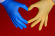 mani con i guanti e i colori dell'Ucraina isolate su sfondo rosso