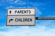 Road sign with words parents and children. White two street signs with arrow on metal pole on blue sky background.
