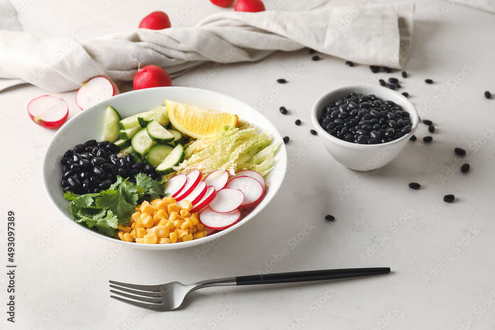 Bowl with ingredients for Mexican vegetable salad and black beans on light background