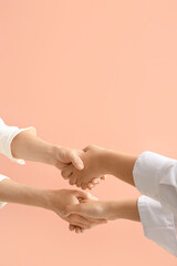 Wall Mural - Businesswomen holding hands together on color background