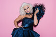 Leinwandbild Motiv drag queen with spectacular makeup holding hand on waist while posing on pink.