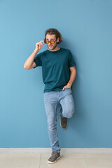 Canvas Print - Handsome young man in stylish t-shirt on blue background