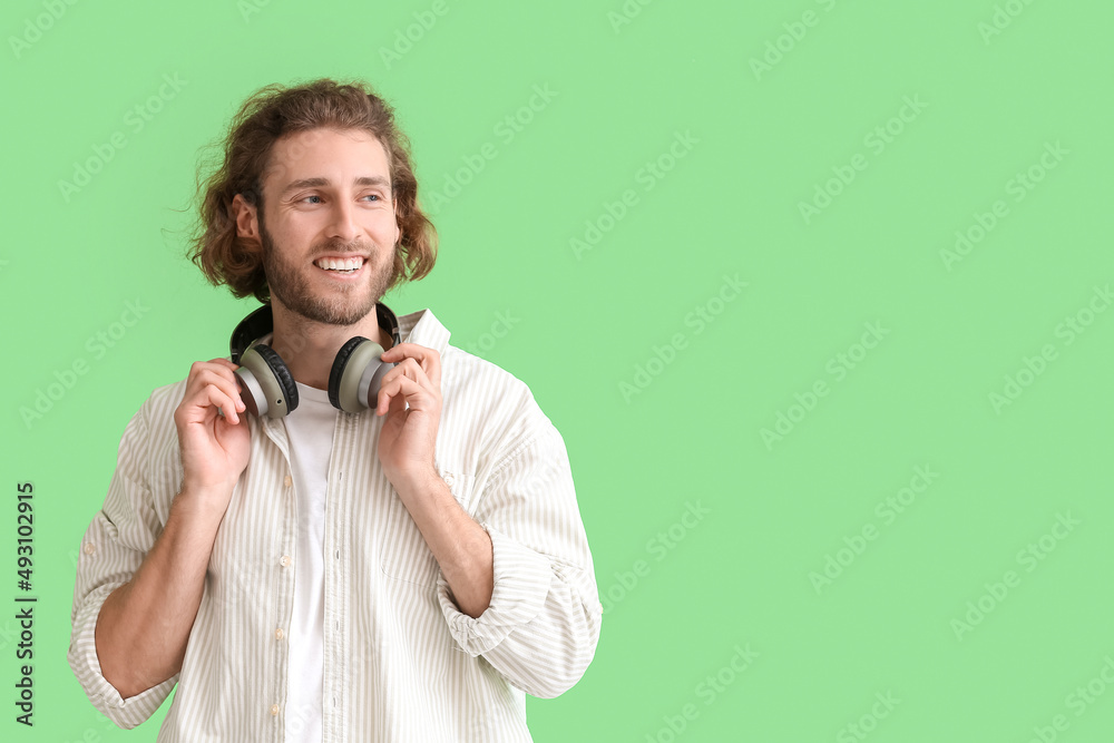 Handsome man with headphones on green background
