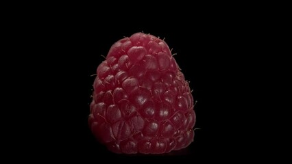 Wall Mural - Close-up of ripe raspberries on a black background. Macro of juicy berry.