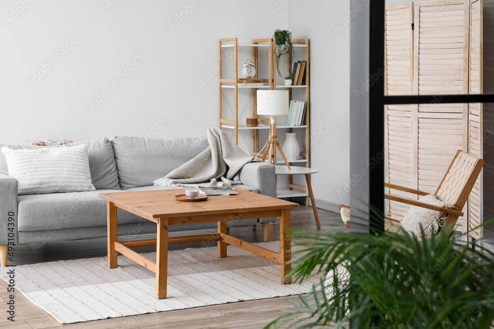 Modern table, sofa and lamp in interior of room
