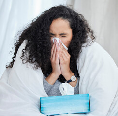 Canvas Print - In our house the only thing that gets recycled is the flu. Shot of an uncomfortable looking young woman blowing her nose while lying in bed at home.