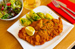Austrian food, pieces of wiener schnitzel with potatoes and lemon on a ceramic plate