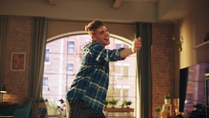 Poster - Portrait of Happy Handsome Young Man Dancing in Casual Home Clothes, Enjoying His Time Alone in His Loft Apartment. Recording Funny Viral Videos for Social Media. Medium Shot.