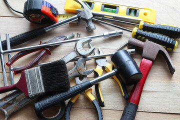 Hardware tools, equipment used for repair and maintenance work in general technicians isolated on wooden background closeup.