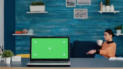 Wall Mural - Modern laptop with green screen template on desk at home, online school class with isolated copy space, blank mockup background and chroma key on display. Computer with technology.