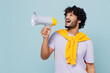 © ViDi Studio - Promoter jubilant young bearded Indian man 20s years old wears white t-shirt hold scream in megaphone announces discounts sale Hurry up isolated on plain pastel light blue background studio portrait.