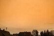 Eine Wolke aus Saharastaub Saharasand verfärbt den Himmel gelb über den Dächern von Meitingen im Landkreis Augsburg in Süddeutschland, ein seltenes Wetterphänomen
