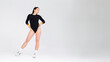 © Andrii  - Attractive girl dancer in a black bodysuit posing in the studio on a white background