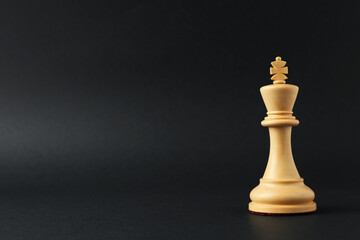 Wall Mural - Wooden king on dark background, space for text. Chess piece