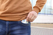 Man putting money into pocket of jeans outdoors, closeup