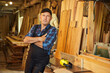 © bondvit - Portrait of Senior carpenter in uniform works on a woodworking machine at the carpentry manufacturing