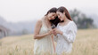 © SHUTTER DIN - two young asian women friends take walking relax and drink coffee cup in her hand at barley field agriculture demonstration plot chiangmai province