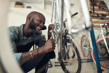Aufkleber - Im almost done fixing this. Shot of a handsome young man crouching alone in his shop and repairing a bicycle wheel.