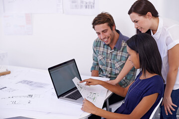 Aufkleber - Three heads are better than one. Shot of a group of young architects working together in the office.