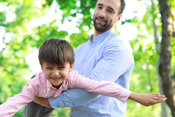 Poster - Little boy having fun with his father in park, closeup