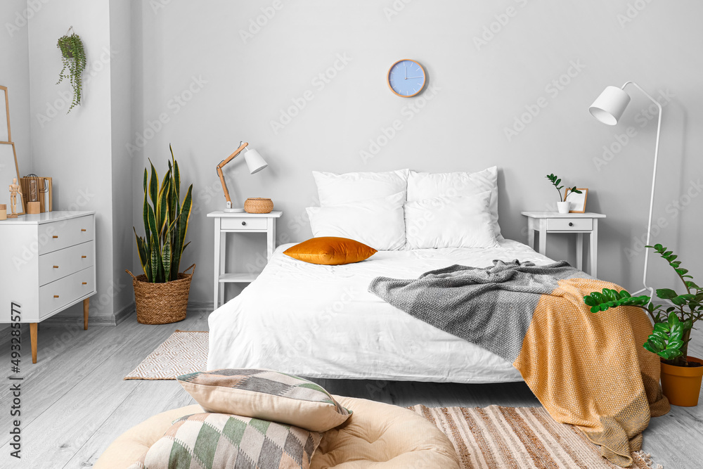 Interior of light room with comfortable bed