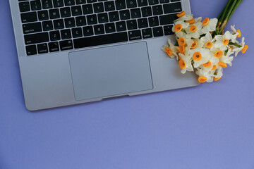 Wall Mural - Cropped shot or laptop computer keyboard and a small bouquet of flowers. Close up, top view, copy space, background, flat lay.