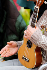 ukulele in woman's hands, sunny day