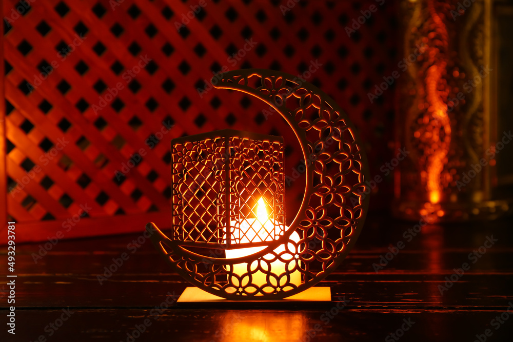 Arabic candle holder with glowing candle on dark background