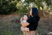 Asian Mother Standing On Hillside With Baby