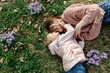 © Sergey Narevskih/Stocksy - Mother and daughter hugging lying on lawn