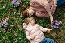 Woman With Little Kid Touching Blooming Crocuses