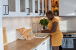 © Anna Berkut/Stocksy - lifestyle, black woman washing dishes in the kitchen